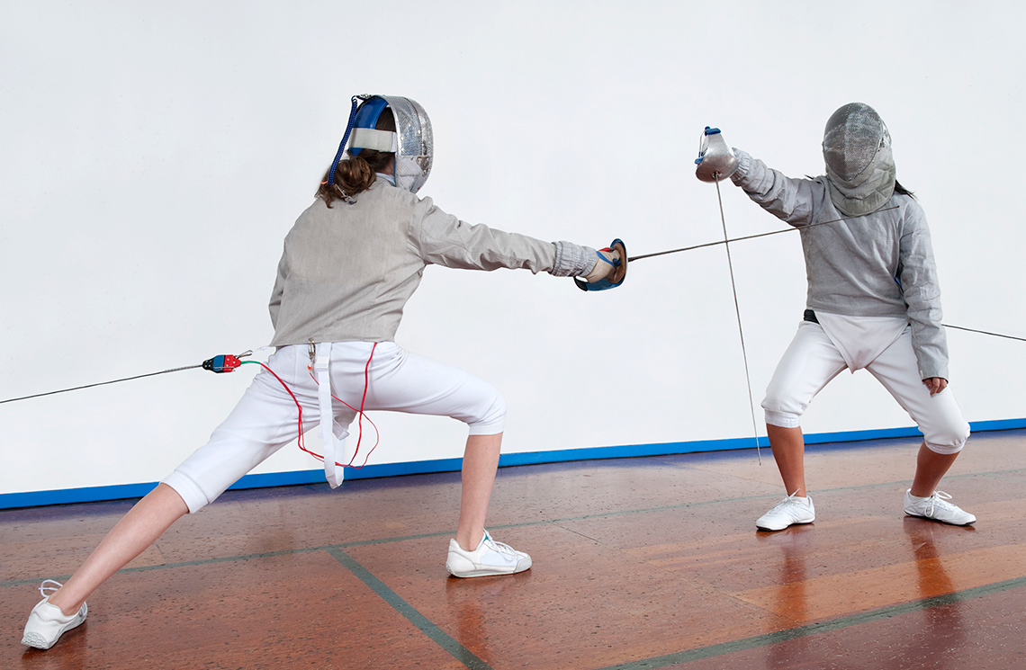 Fencers with face protection on.