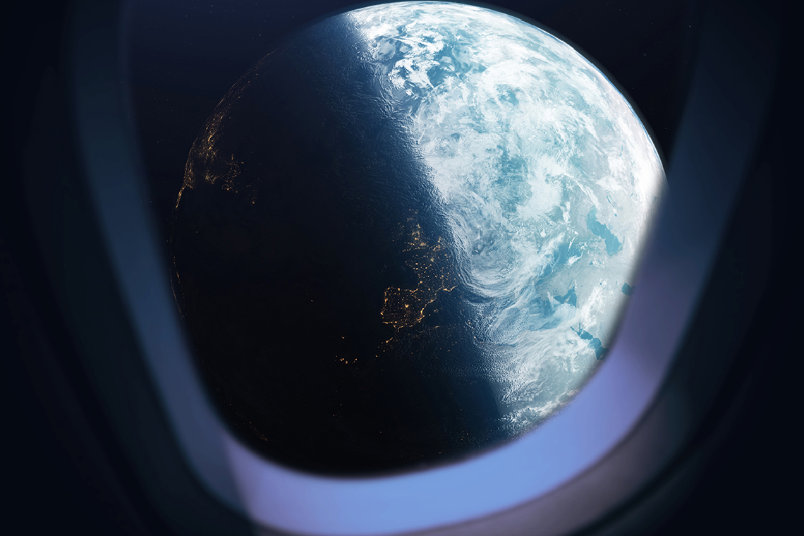 Planet Earth half in shadow as seen through the window of a spacecraft.