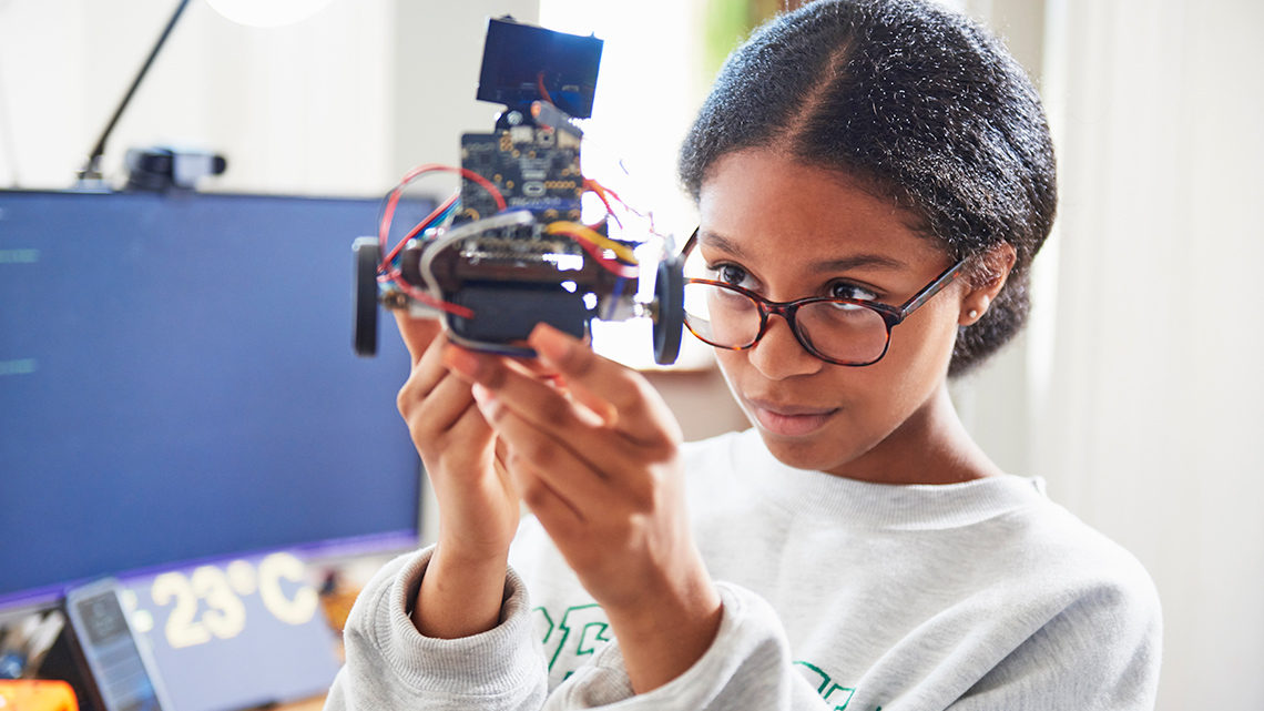 A student examining a robot.