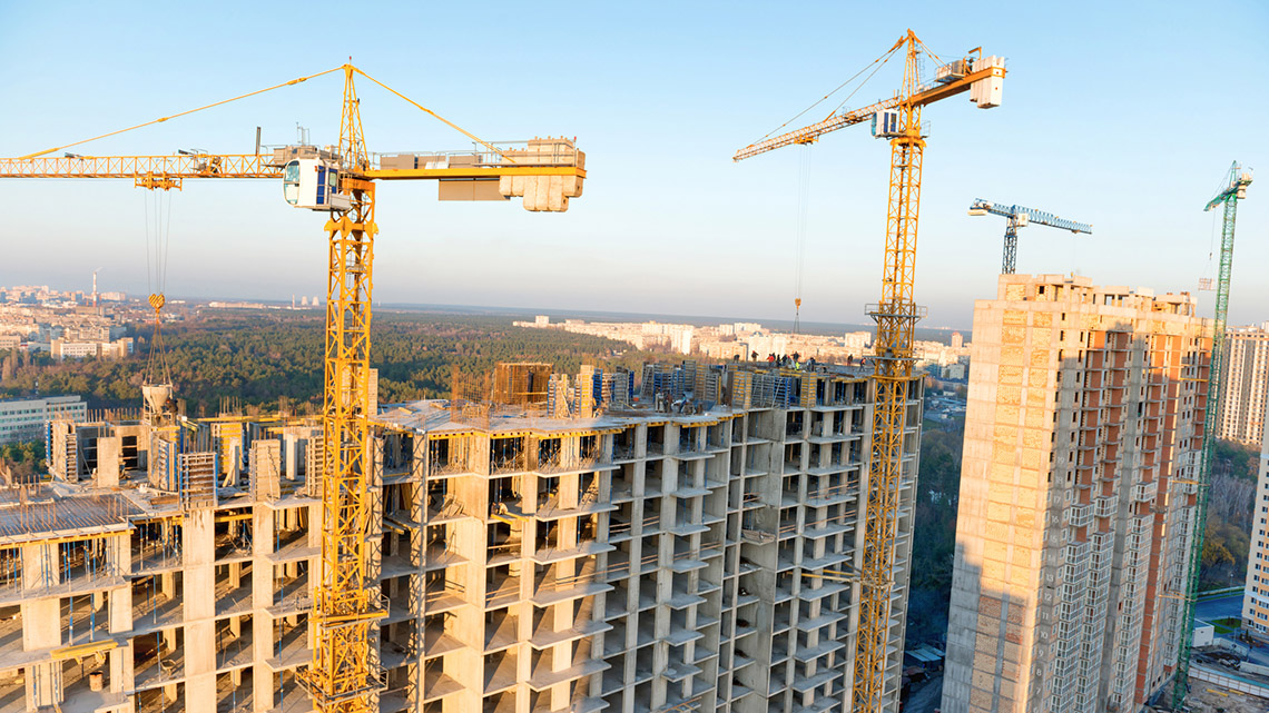 Construction on high rise buildings with cranes in the sky.