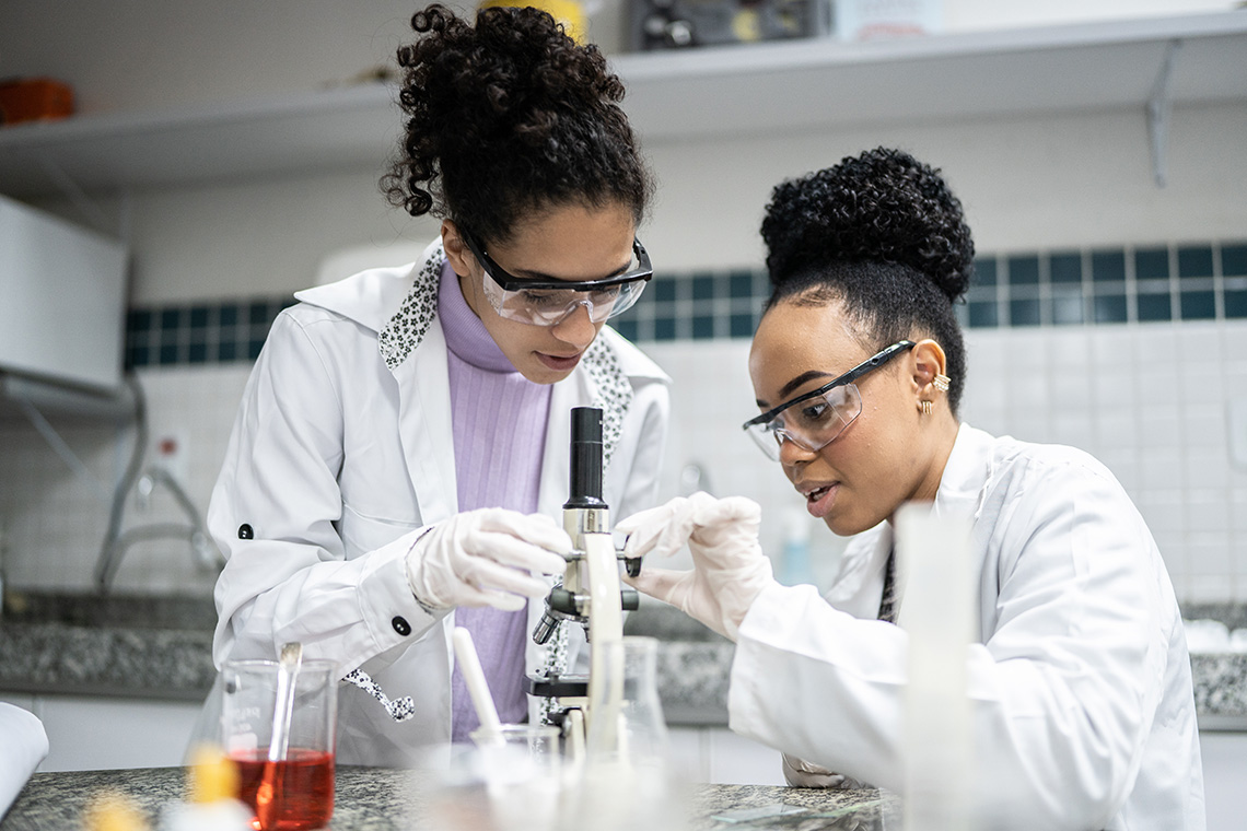 Two scientists using a microscope.