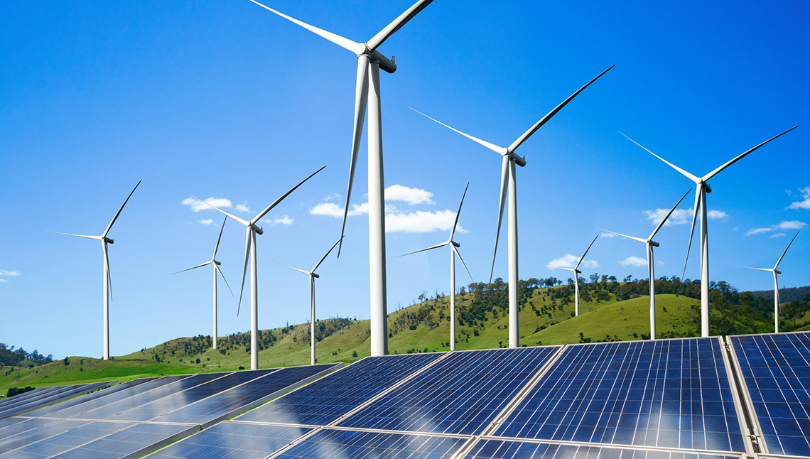 A field with solar panels and wild turbines.