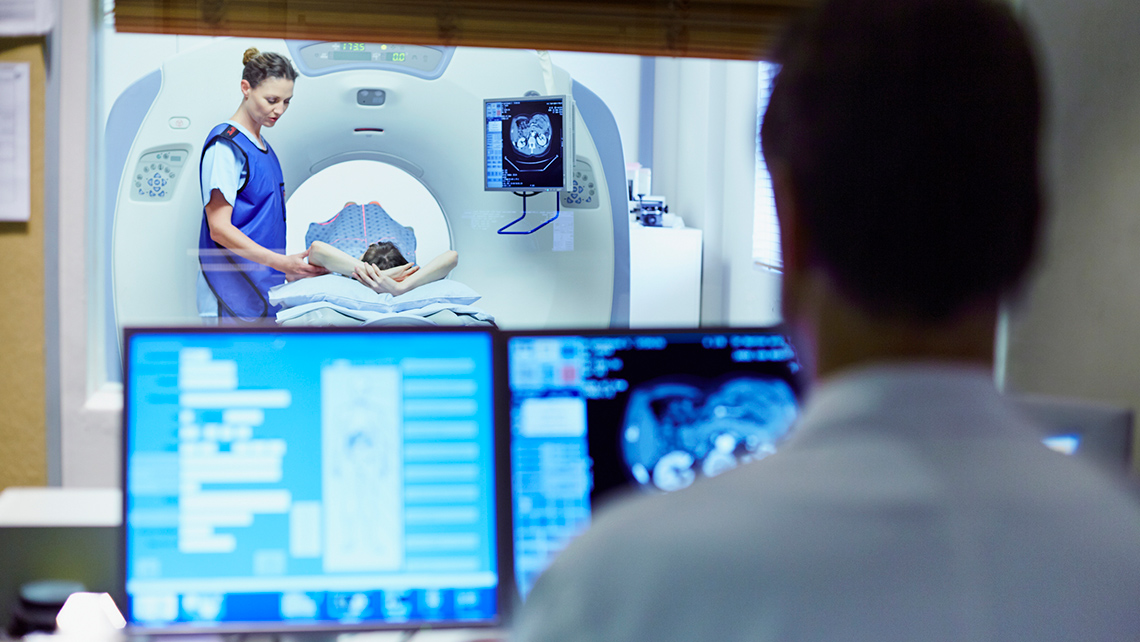 Doctor preparing a patient for a CT scan.
