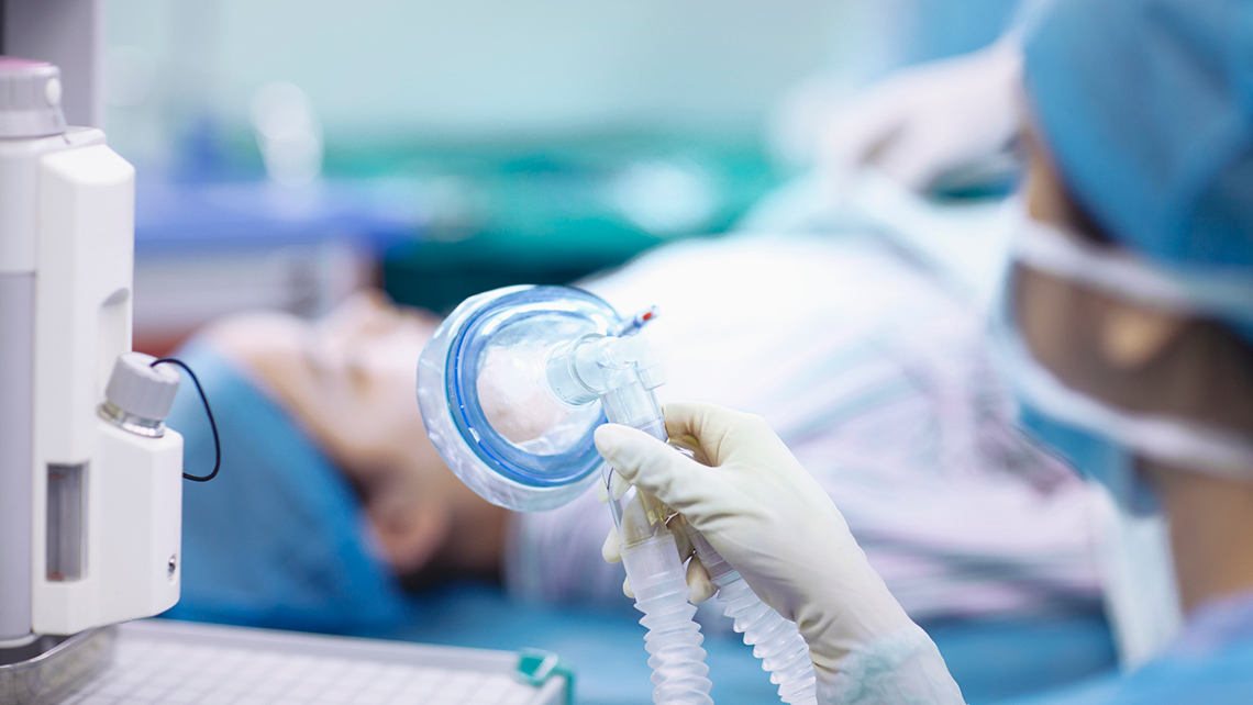 Nurse holding an anesthesia mask in the operating room.