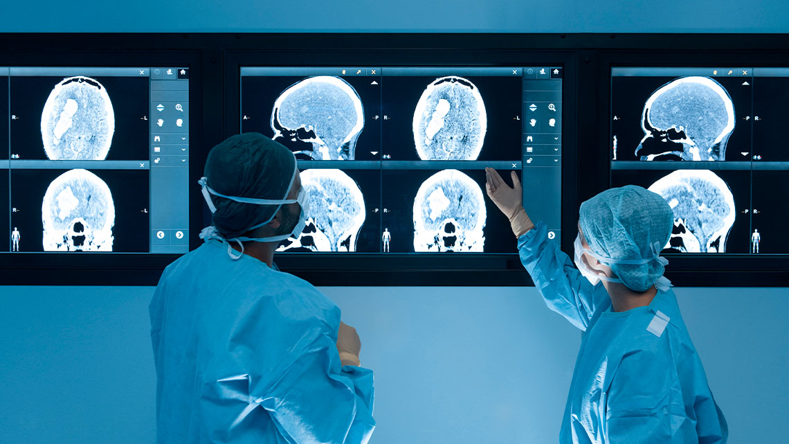 Two medical professionals studying the results of medical imagery on a screen.