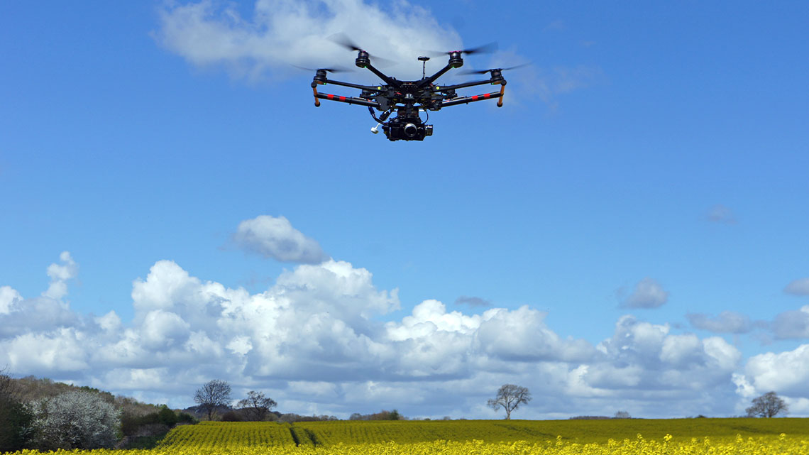 A drone is flying over a field taking pictures.