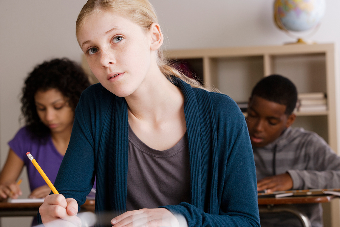A student copying notes into their notebook.