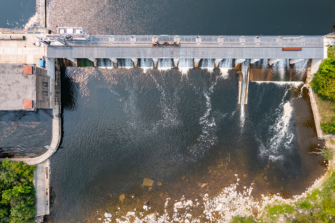 A large dam with water flowing through.