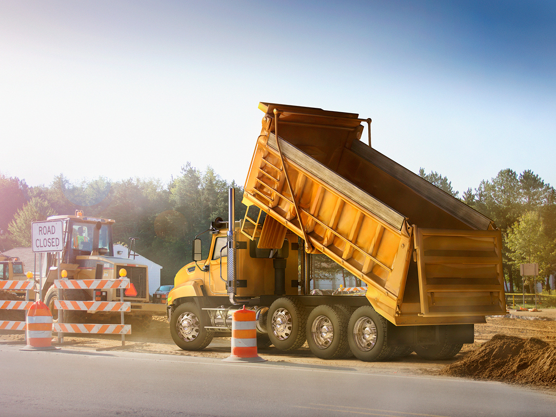 A dump truck with the truck bed raised.