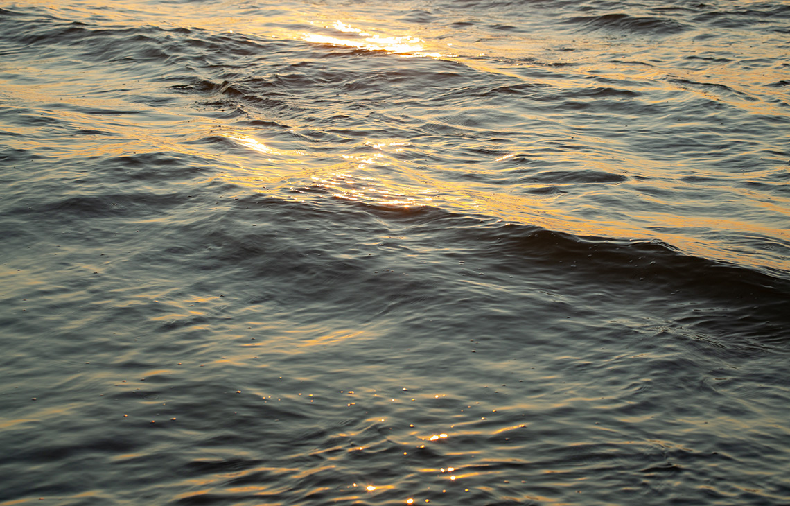 Sun reflecting on the surface of flowing water.
