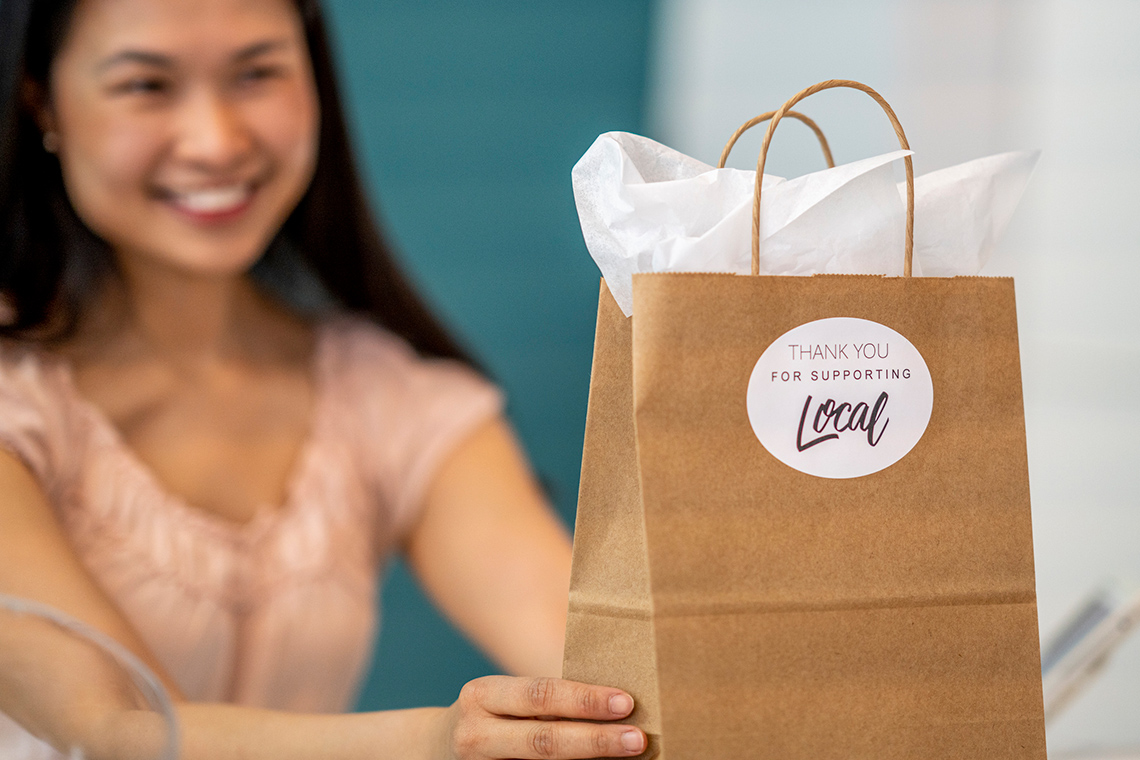 Person holding paper bag with tissue paper.