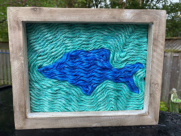 Dolphin artwork made of two colours of lobster rope.