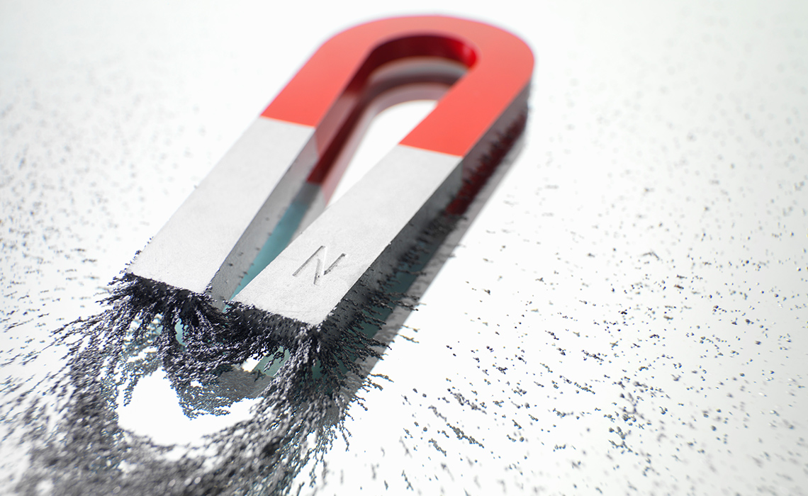 Metal filings being drawn toward the ends of a magnet.