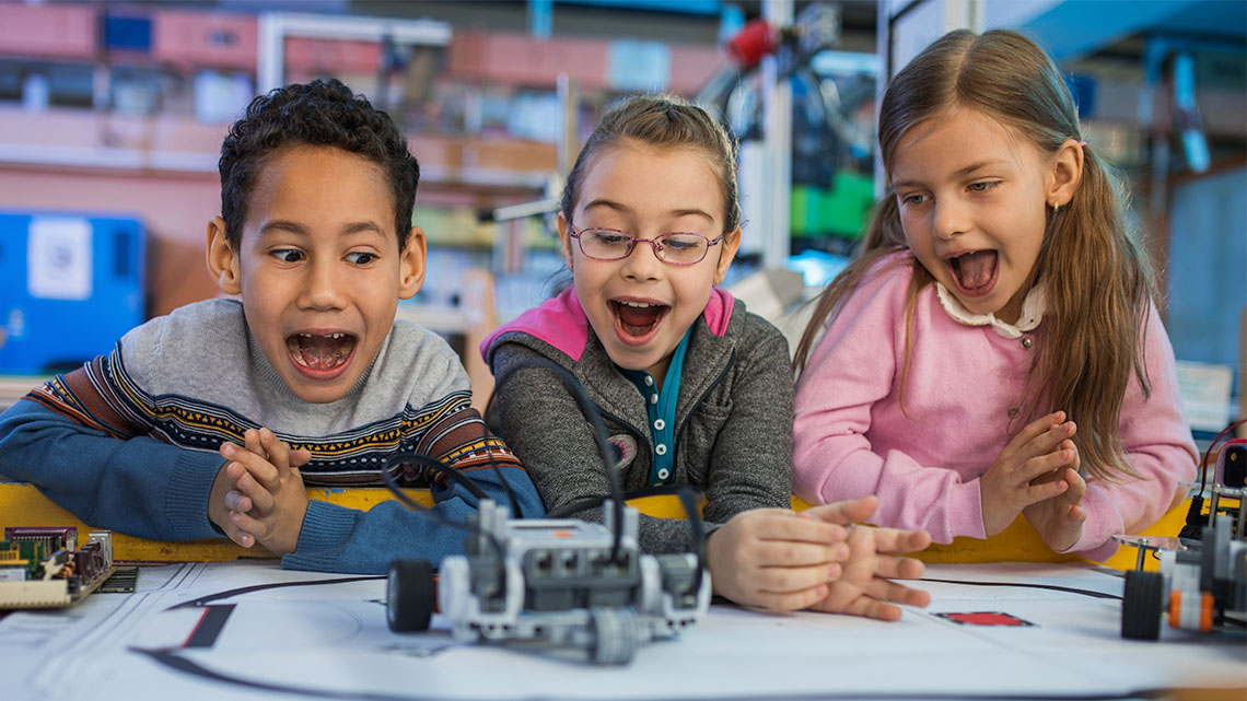 Three excited children playing with a toy robot.