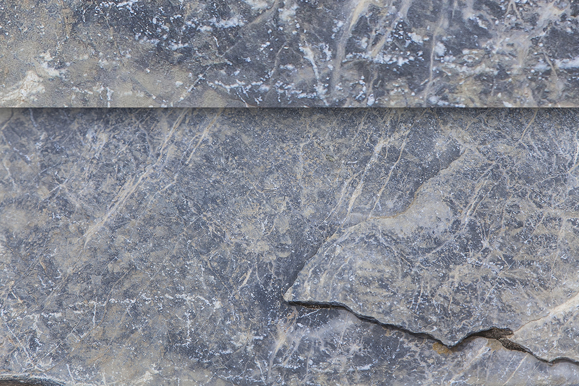 Light grey rock with random streaks of white and beige, and few cracks or fissures.