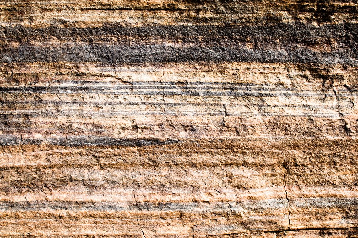 Sedimentary rock in nature. It is layered and bumpy.