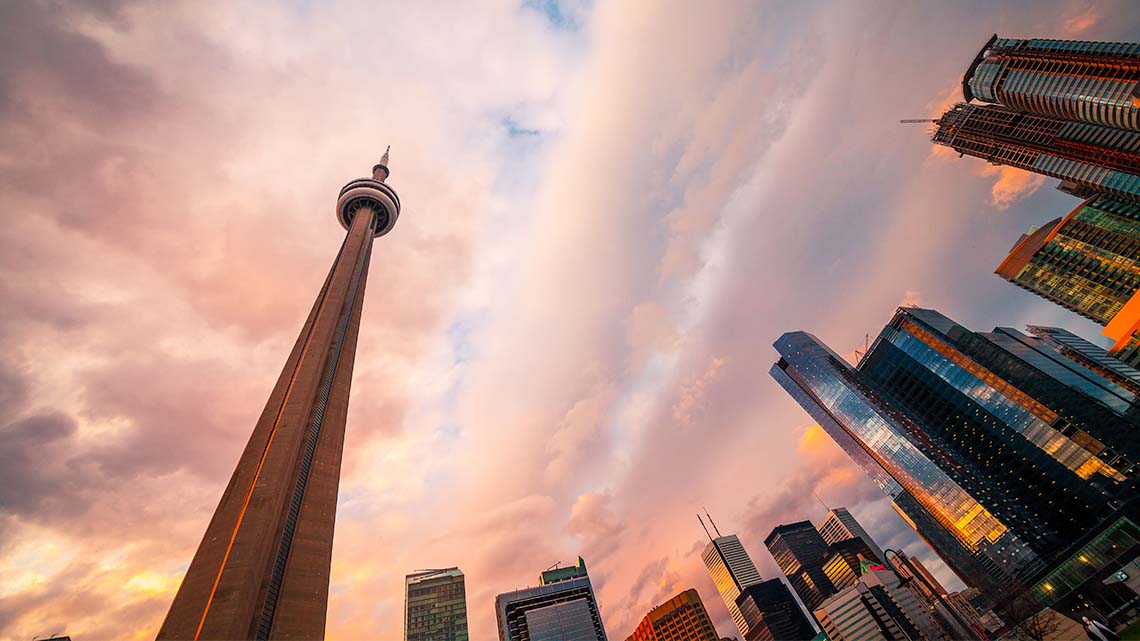 A view of the CN tower and other buildings along the Toronto skyline from below.