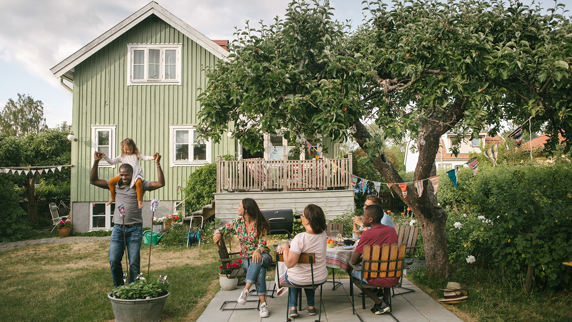 Summer house with an open backyard. Family and friends gather in the backyard.