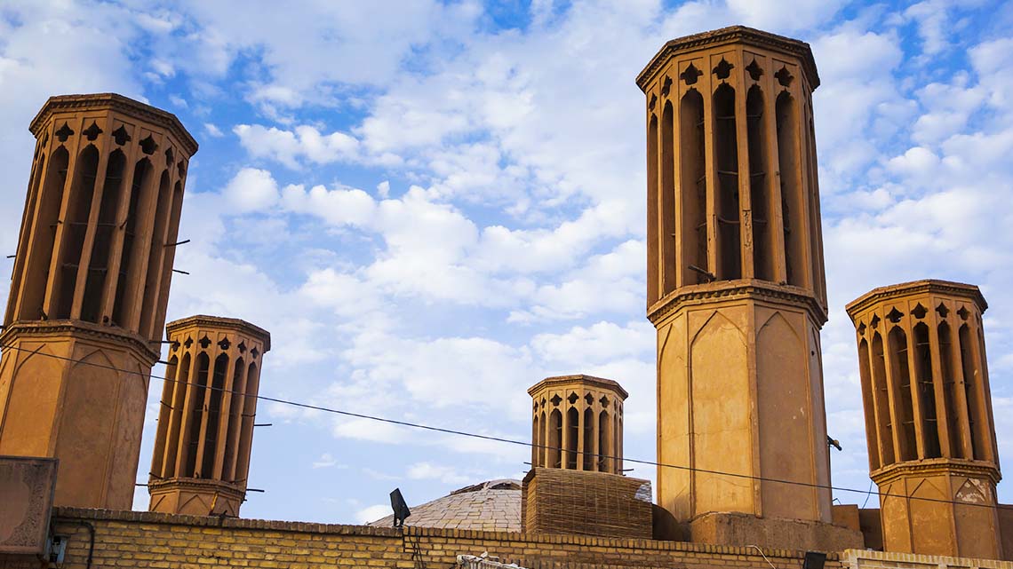 Tall, skinny towers with multiple large openings at the top on the roof of a building.