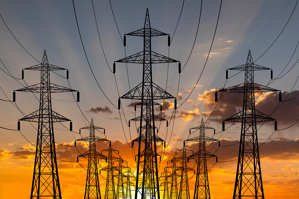 High voltage towers Rows of high voltage towers with connecting power lines against a sunset background.
