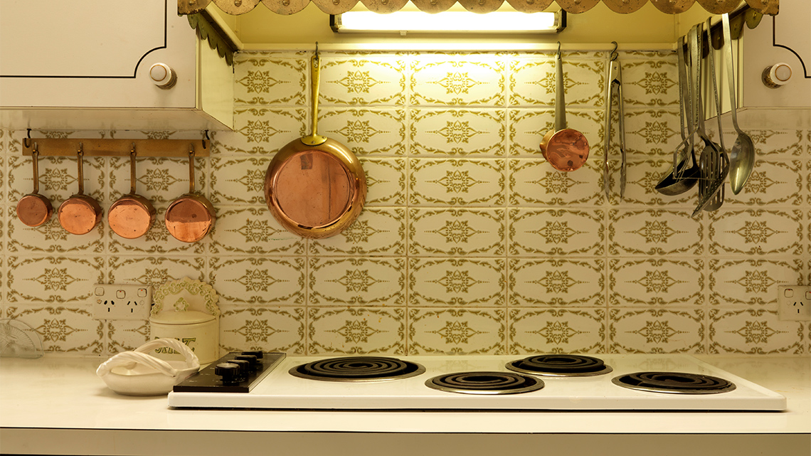 An electric stovetop with a light on above it in the rangehood.
