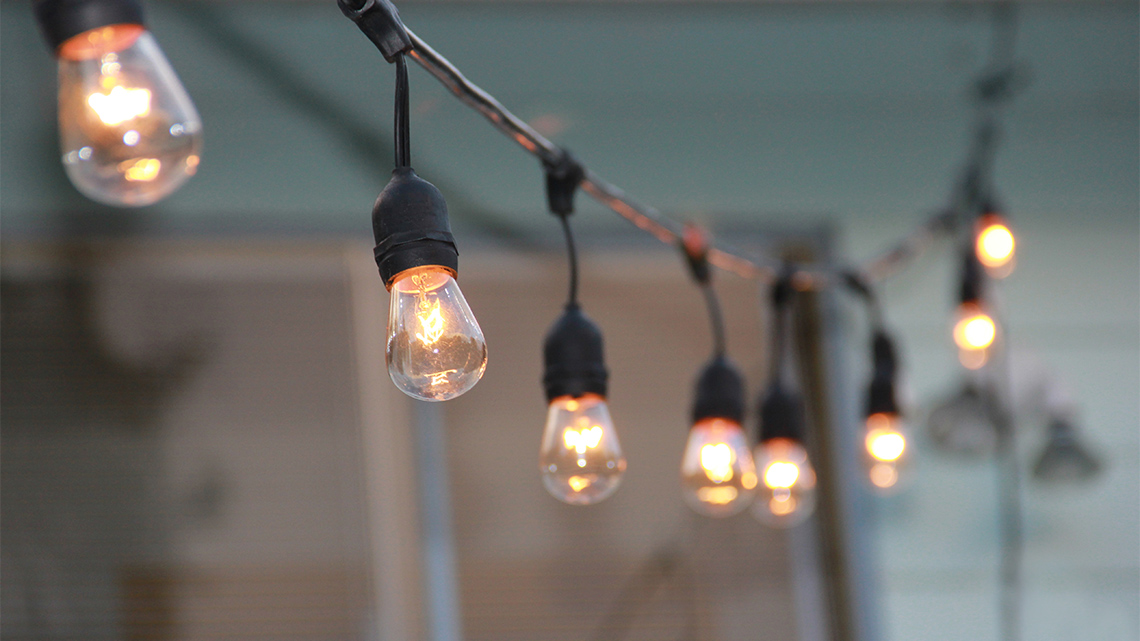A string of lightbulbs hanging in the dark.