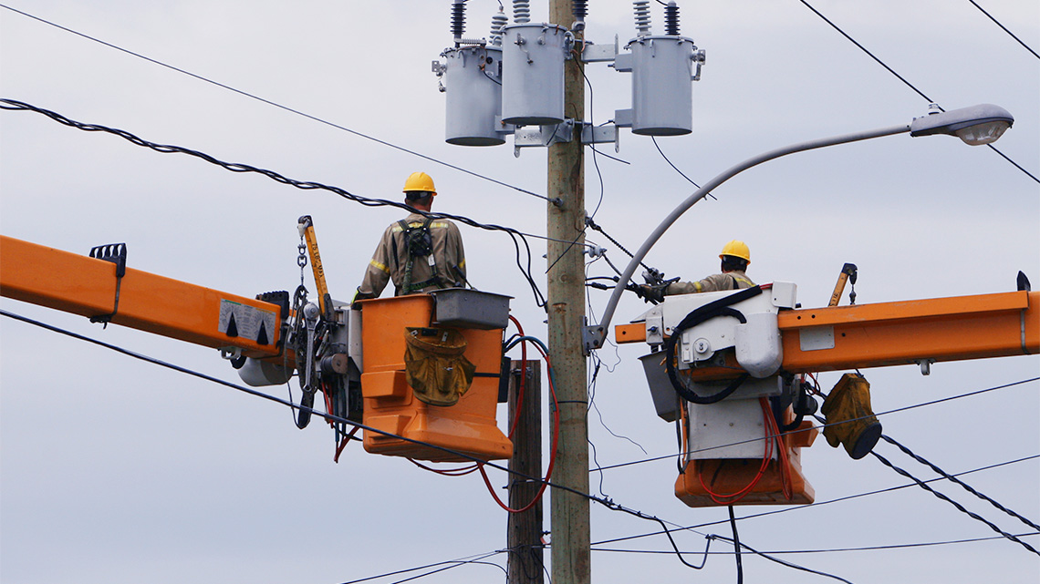 Two electricians inspecting the hydro lines