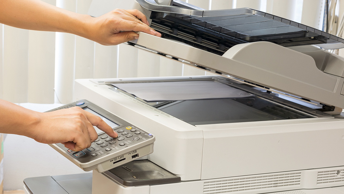 A person using a photocopier to make copies.