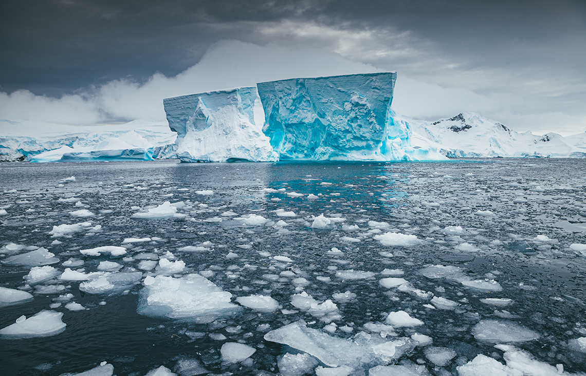 An iceberg surrounded by water and ice. 