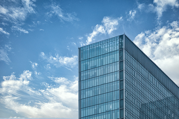 A tall building reaching into the sky. Each side is made of glass.