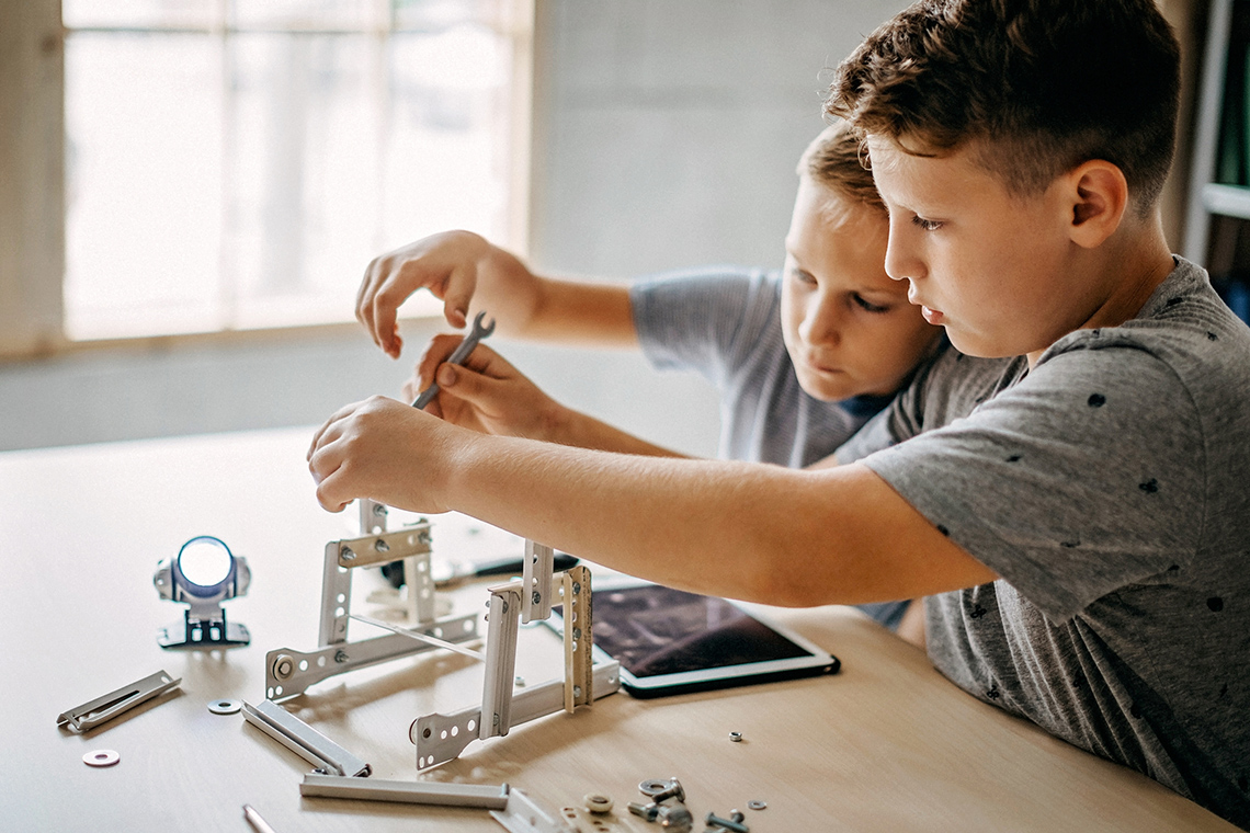 Two children building a robot.
