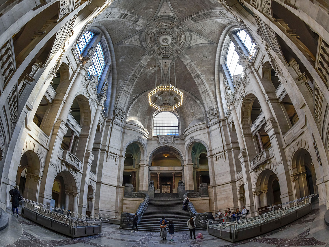 Interiors of a city hall with large curved windows and entryways.