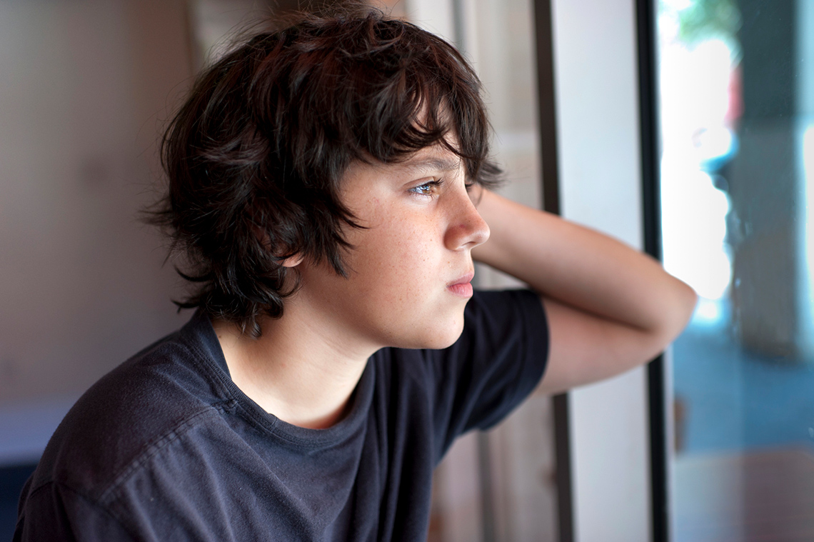 A student looking out a window and thinking.