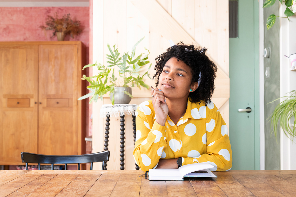 A person sitting at a table with a notebook in front of them.