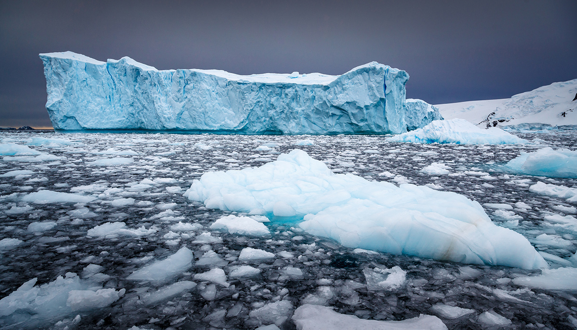 An iceberg surrounded by ice floating in the water.
