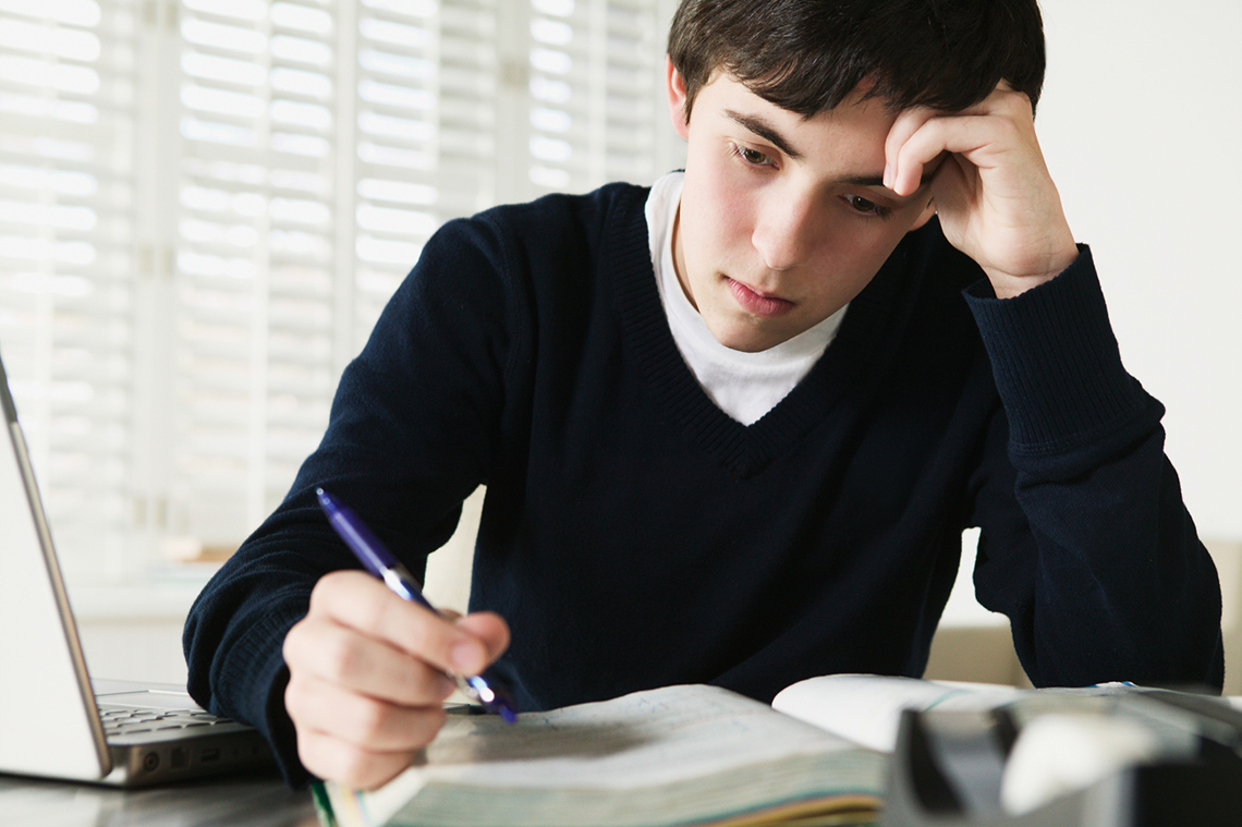 A person looking at their notebook and thinking.