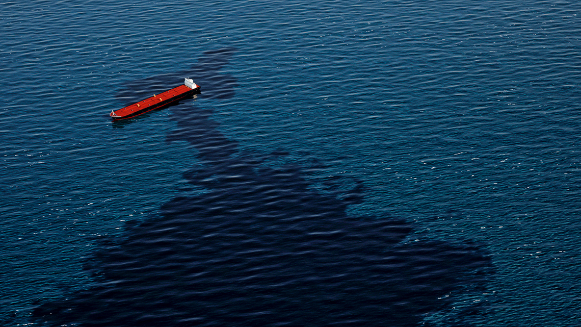 An oil tanker with a large oil slick in the sea.