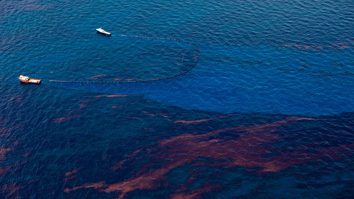 Two boats skimming oil off the surface of the water.
