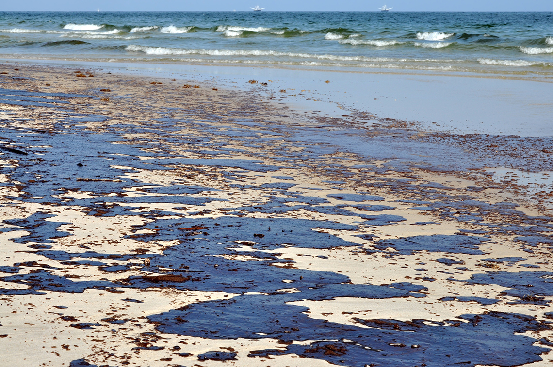 Oil covering the sand on a beach. 
