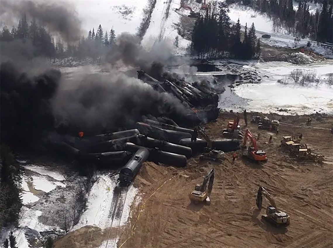 A train crashed with oil spilling from the cars.