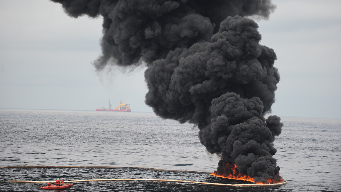A fire burning on top of the surface of the water. 