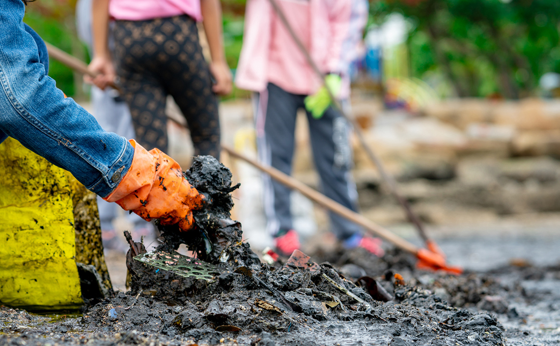 Young people cleaning up a shoreline.