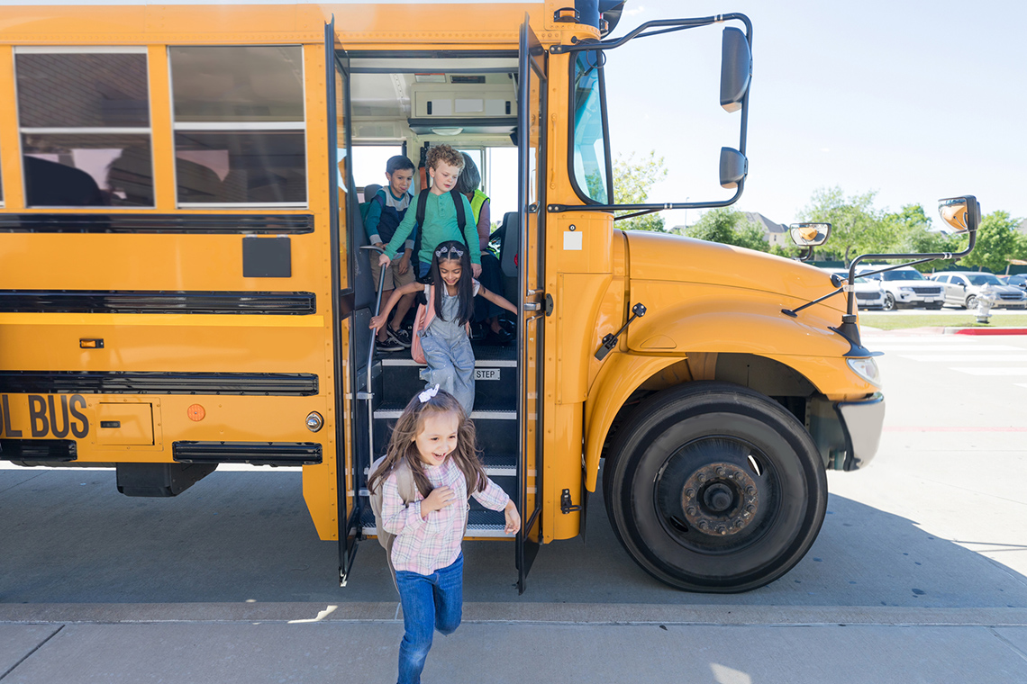 Kids getting off a school bus.