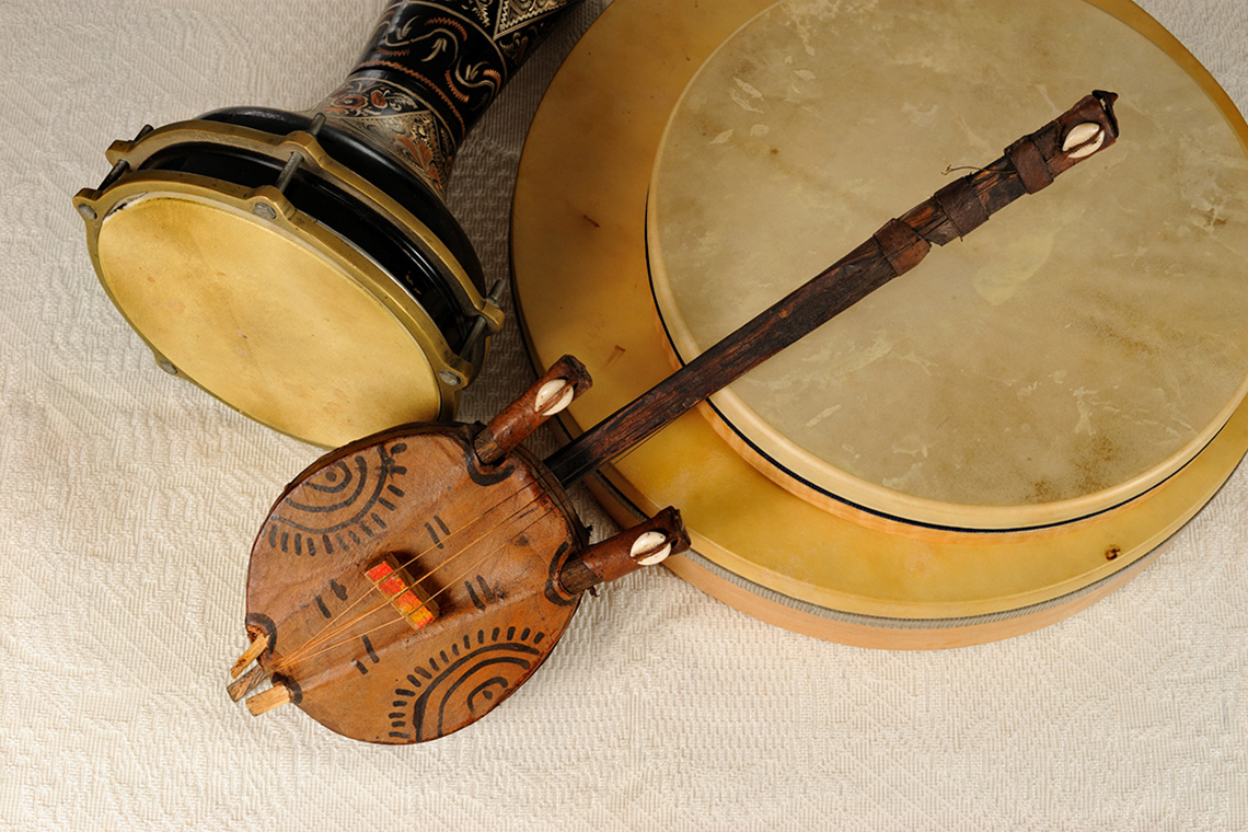 A Kora, which is a string instrument resembling a guitar, surrounded by percussion instruments. 