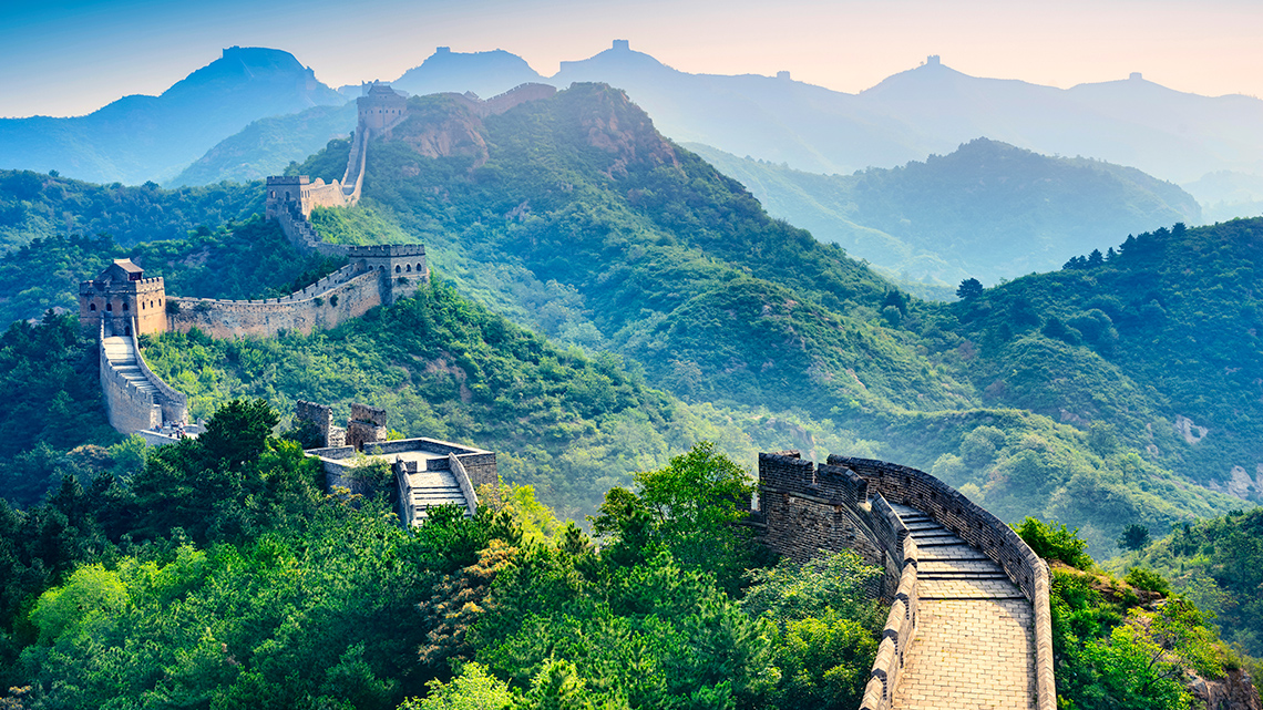 The Great Wall of China, China Sunrise over the Great Wall of China. The wall stretches over many regions in a zig-zag pattern.