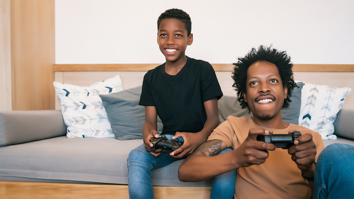 A child sits on a couch and plays a video game console.