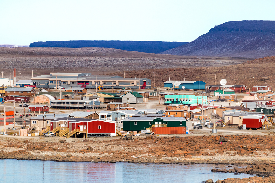 A coastal town on the island Ulukhaktok with small colourful buildings.