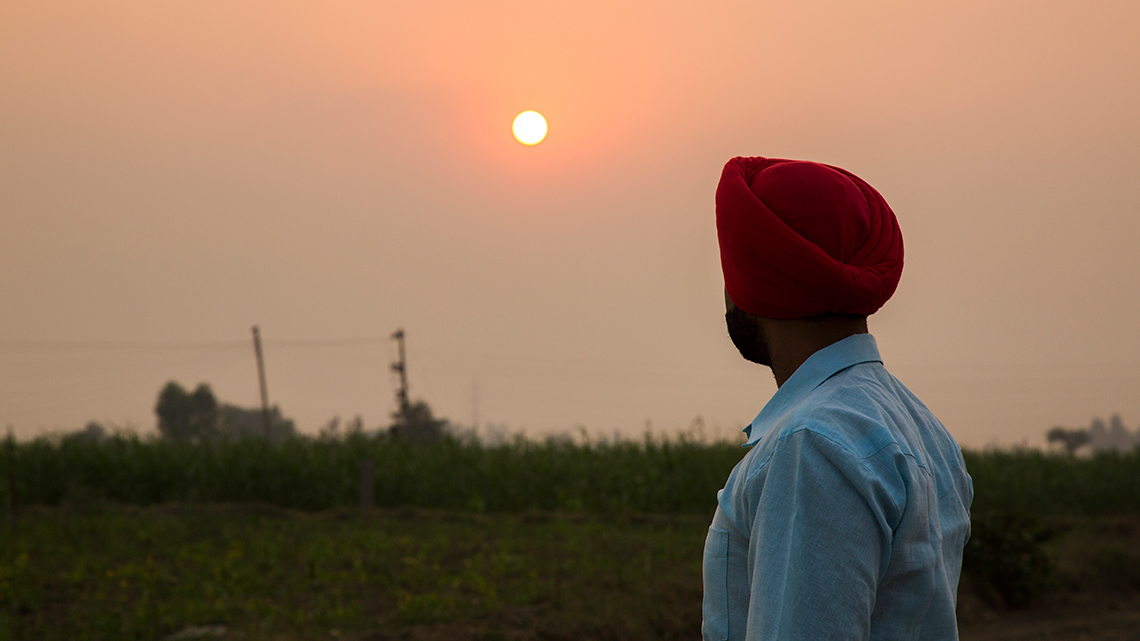 A Sikh person wearing a turban and standing outside in the Punjab Region of India