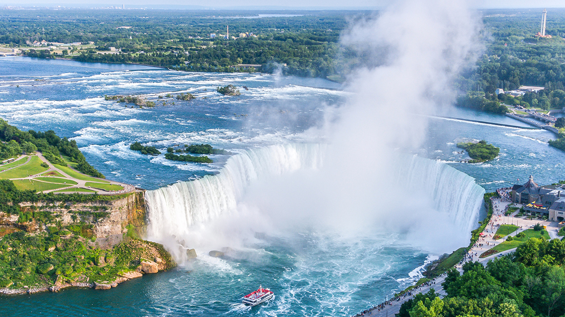 A view of Niagara Falls from the sky. The powerful waterfall drops into a pool below.