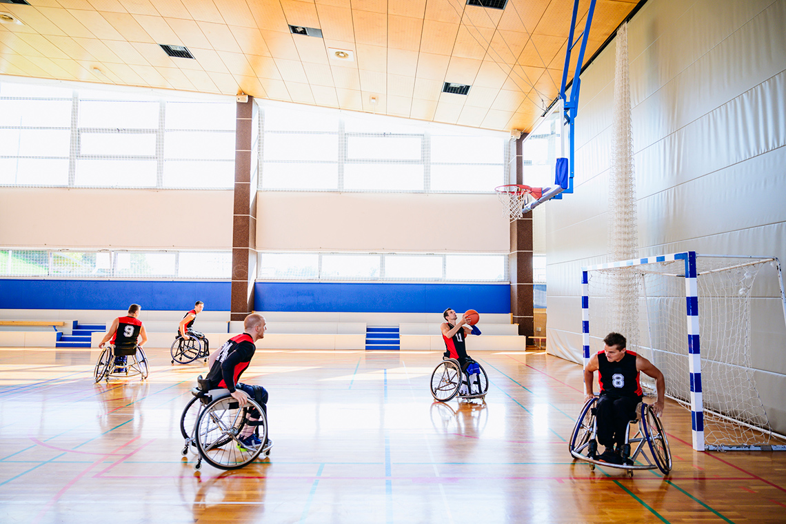 A team of basketball players in wheelchairs, practicing drills.